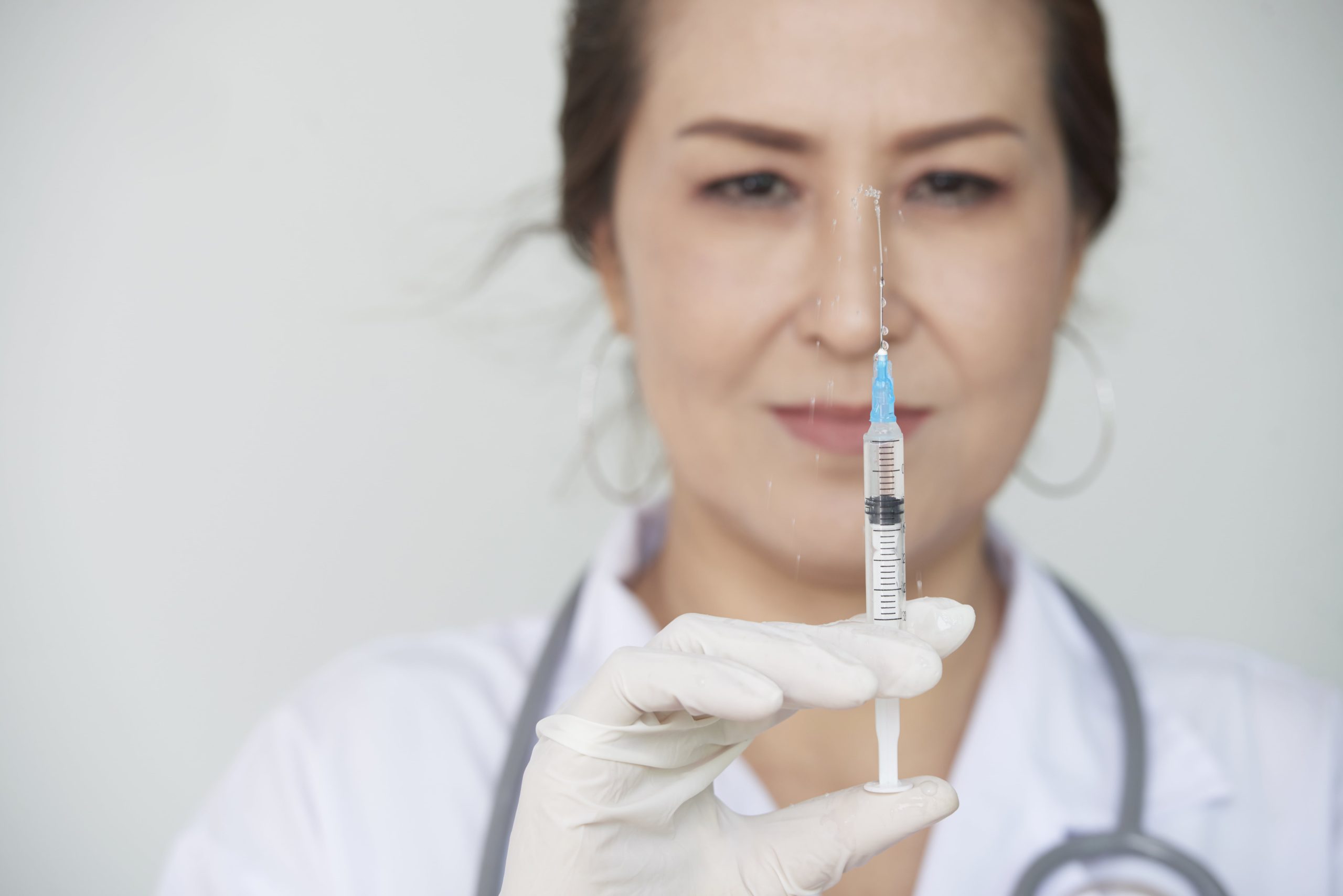 female practitioner holding radiesse syringe